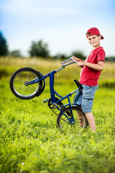 Young boy riding bicycle in a park — Stock Photo, Image