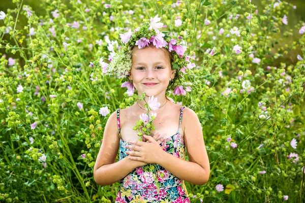 Porträtt av en liten flicka i krans av blommor — Stockfoto