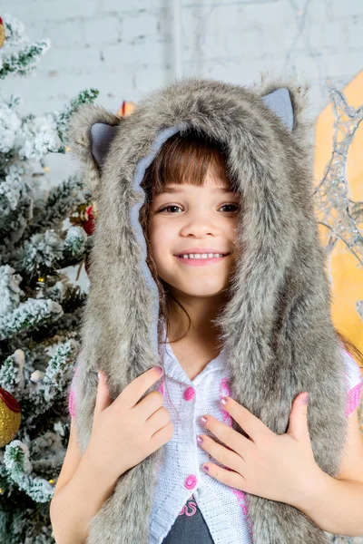 Милая маленькая счастливая девочка, позирующая в меховой шляпе . — стоковое фото