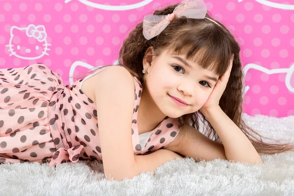 Маленькая милая девочка на ковре из меха — стоковое фото