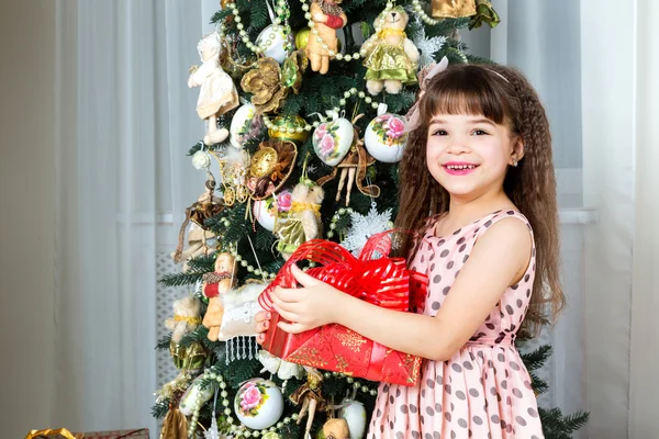 Boldog kis lány mosolyogva karácsonyi jelen — Stock Fotó