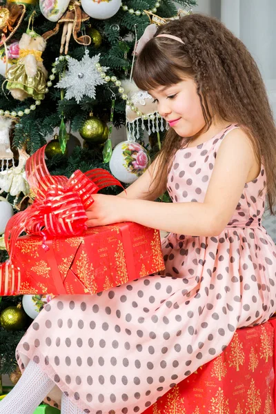 Happy little girl with christmas present smiling — Stock Photo, Image