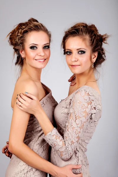 Dos niñas gemelas, aisladas sobre el fondo gris —  Fotos de Stock