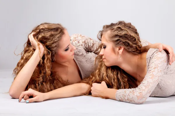 Zwei Mädchen Zwillinge, isoliert auf dem grauen Hintergrund — Stockfoto
