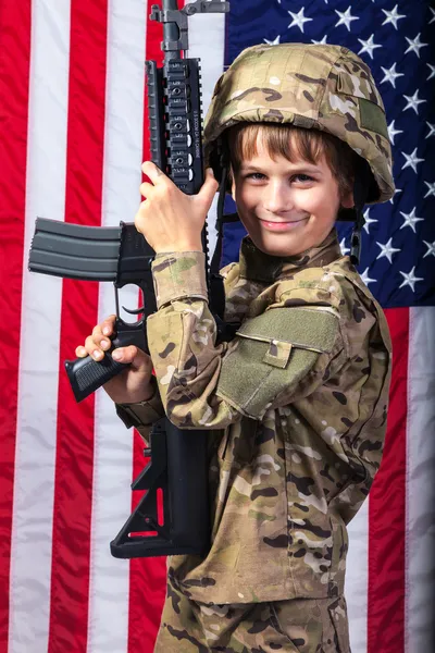 Niño vestido como un soldado con bandera americana — Foto de Stock