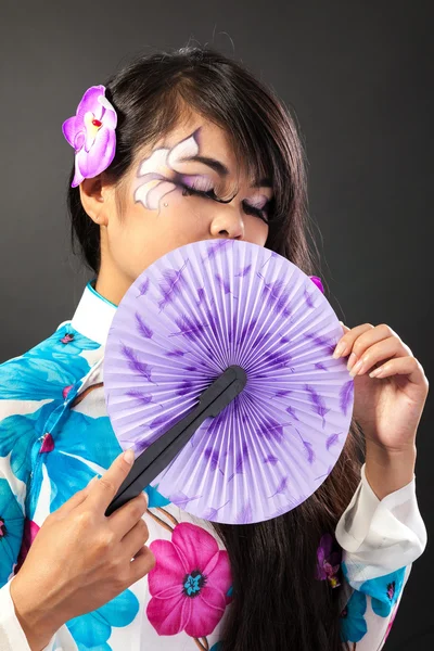 漂亮的亚洲女子穿民族服饰持有一个风扇 — 图库照片