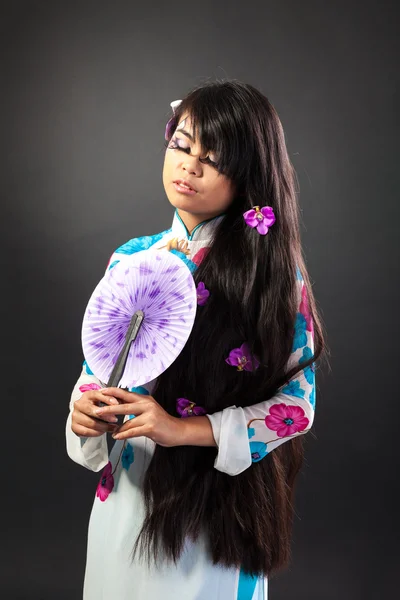 Beautiful asian woman wears a national dress is holding a fan — Stock Photo, Image