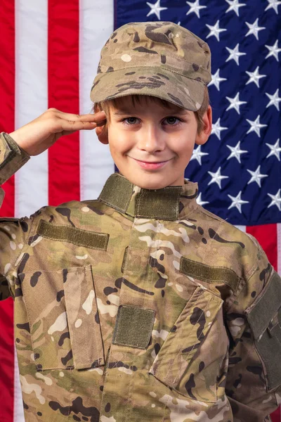 Nuori poika pukeutunut kuin sotilas Amerikan lippu — kuvapankkivalokuva
