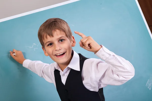 School student writing on blackboard at school — Stock Photo, Image