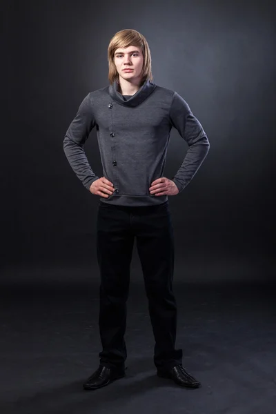 Young man standing on grey background — Stock Photo, Image