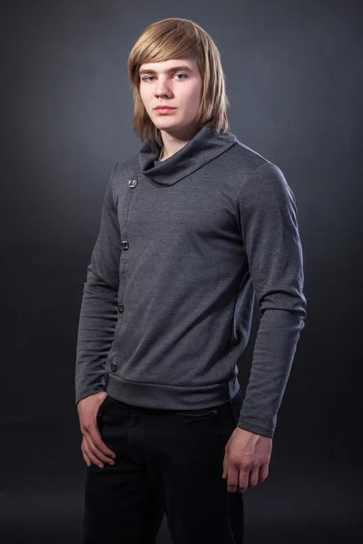 Young man standing on grey background — Stock Photo, Image