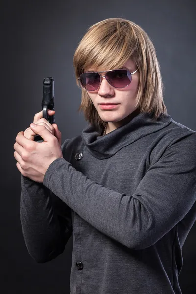 Allvarlig man med glasögon och med pistol — Stockfoto