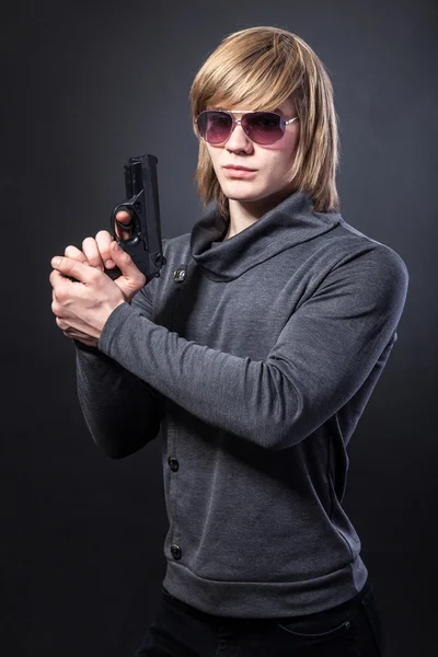 Серйозна людина в окулярах і з пістолетом — стокове фото