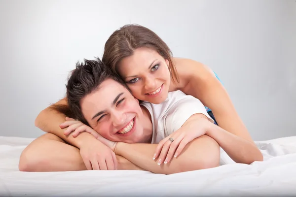 Young couple lying on the bed head to head — Stock Photo, Image