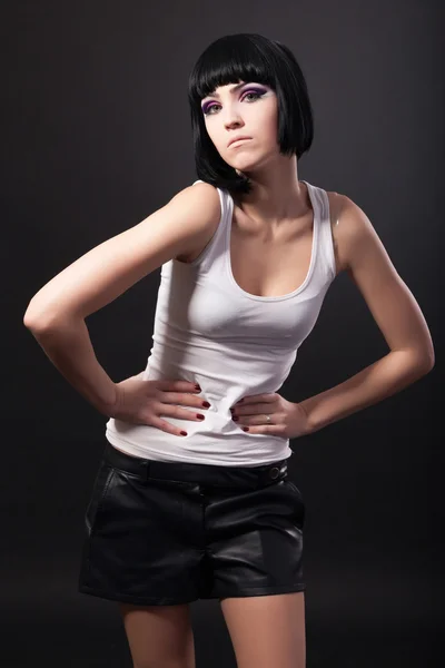 Portrait of a brunette woman standing with hands on waist — Stock Photo, Image