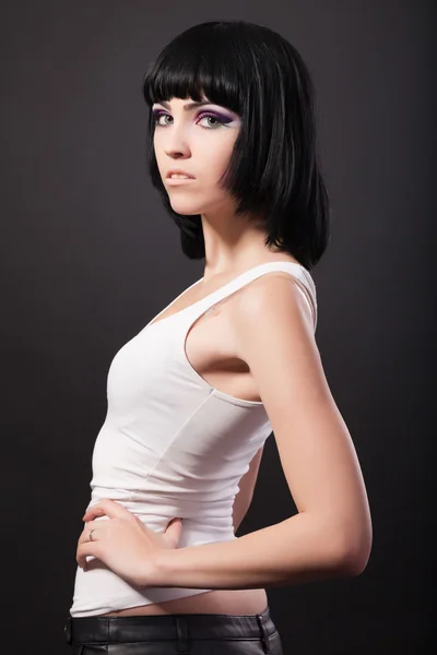 Portrait of a brunette woman standing with hand on waist — Stock Photo, Image