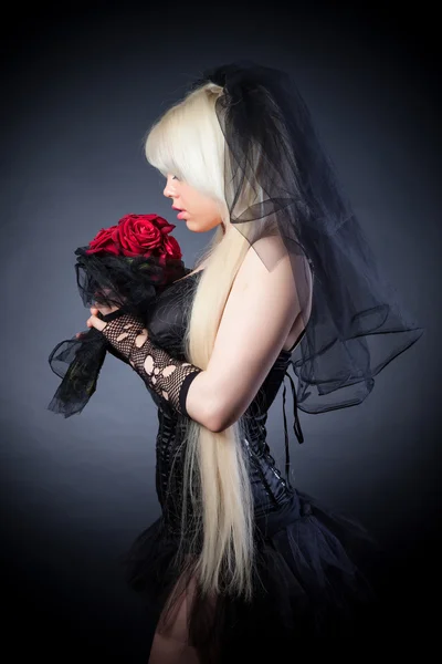 Portrait of a woman in black with flowers — Stock Photo, Image