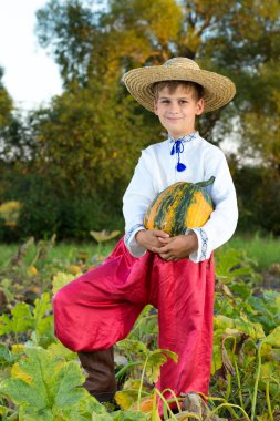 büyük sarı kabak elinde tutan çocuk gülümseyen