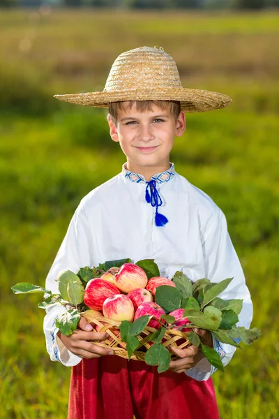 Happy farmer boy håller ekologiska äpplen på hösten trädgård — Stockfoto