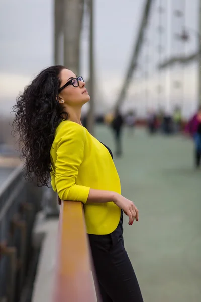 Menina bonita está em uma ponte ao ar livre — Fotografia de Stock