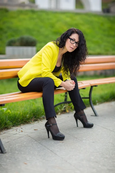 Schönes Mädchen sitzt auf einer Parkbank — Stockfoto