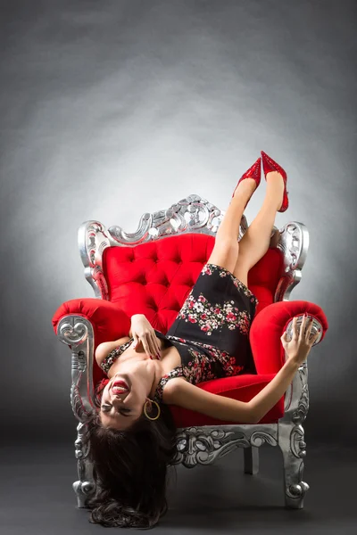 Jonge vrouw in een rode stoel. retro stijl. — Stockfoto