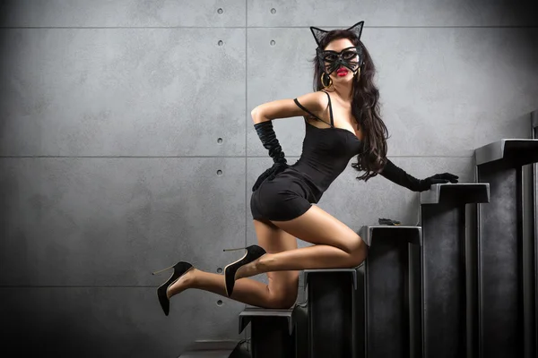Sexig kvinna i catwoman dräkten liggande på trappan Royaltyfria Stockfoton
