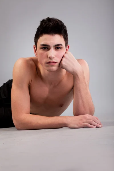 Friska muskulös ung man på grå bakgrund — Stockfoto