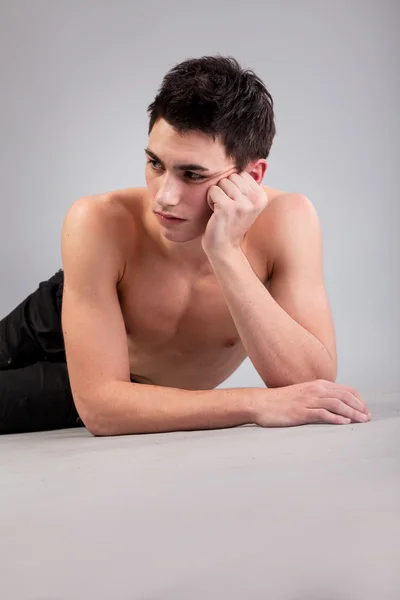 Jeune homme musclé en bonne santé sur fond gris — Photo