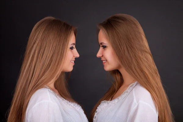 Zwei schöne Mädchen Zwillinge, isoliert auf schwarz — Stockfoto