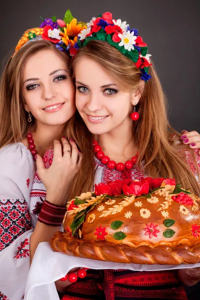 Jovens mulheres em roupas ucranianas, com guirlanda e pão redondo — Fotografia de Stock