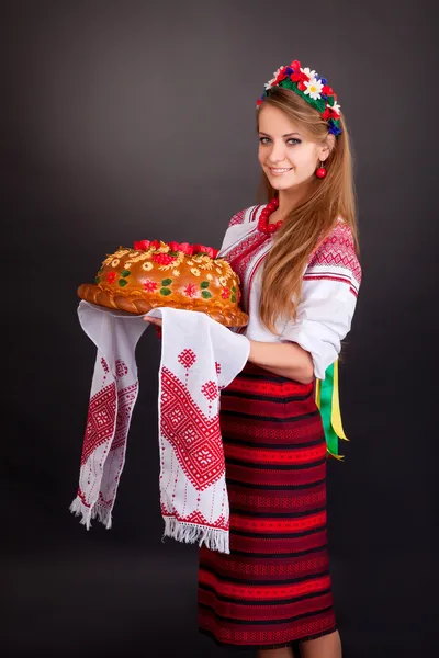 Jovem mulher em roupas ucranianas, com guirlanda e pão redondo — Fotografia de Stock