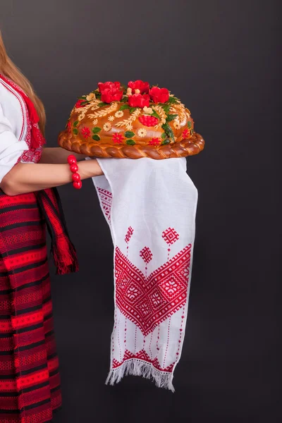 Jeune femme en vêtements ukrainiens, avec guirlande et pain rond — Photo