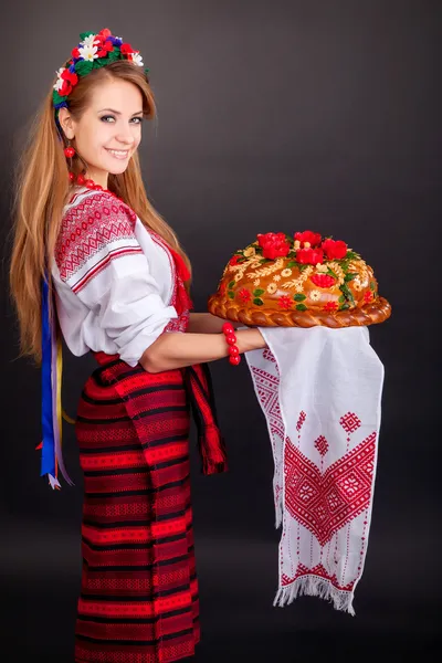 Jovem mulher em roupas ucranianas, com guirlanda e pão redondo — Fotografia de Stock