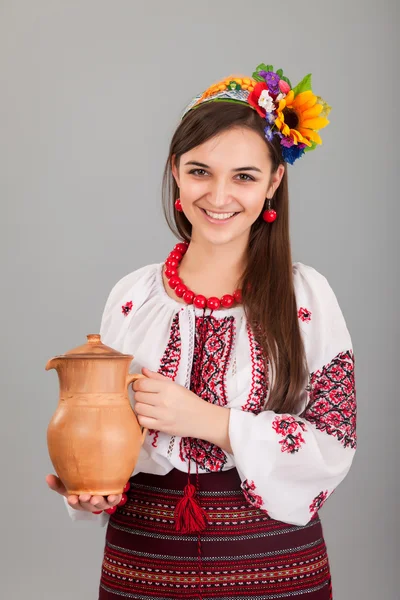魅力的な女性は身に着けているウクライナは水差しの国民の服を保持しています。 — ストック写真