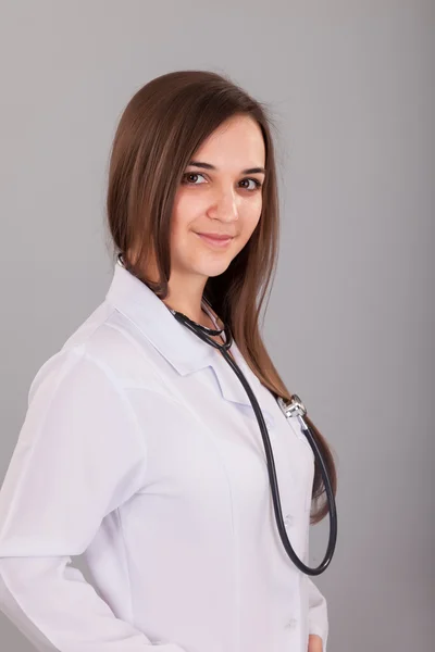 Joven y hermosa enfermera en un gris — Foto de Stock