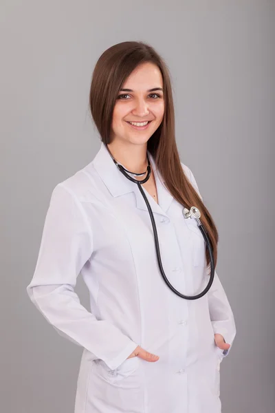 Joven y hermosa enfermera en un gris — Foto de Stock