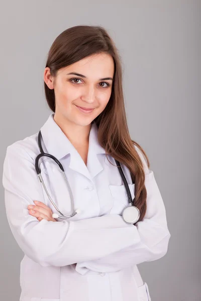 Jonge en mooie verpleegster op een grijs — Stockfoto
