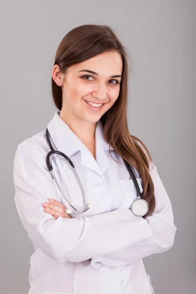 Ung och vacker sjuksköterska på en grå — Stockfoto