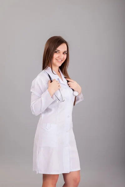 Joven y hermosa enfermera en un gris — Foto de Stock