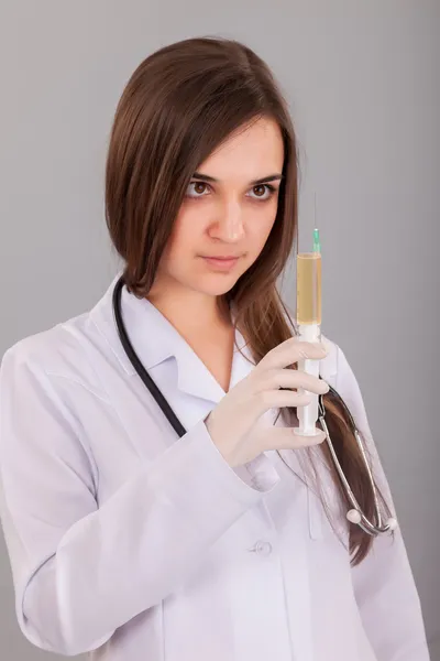 Женщина-врач держит наполненный шприц — стоковое фото