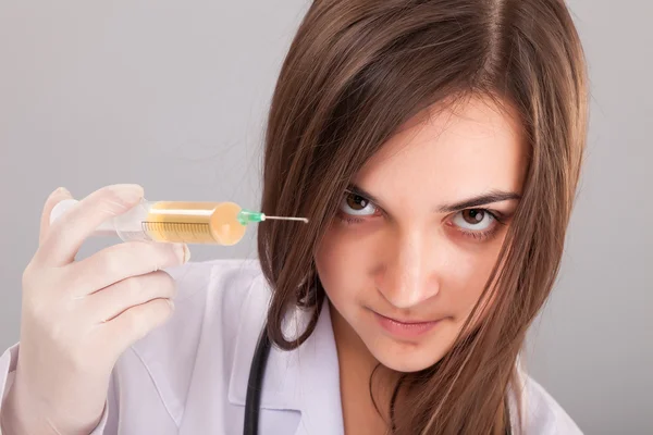 Mulher médico segurando uma seringa cheia — Fotografia de Stock