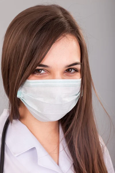 Krankenschwester lächelt hinter Chirurgenmaske. Nahaufnahme Porträt von — Stockfoto