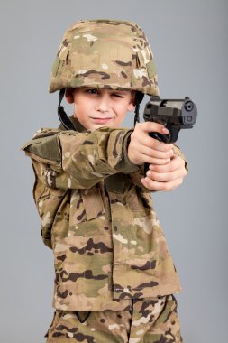 elinde silah olan bir asker gibi giyinmiş genç çocuk