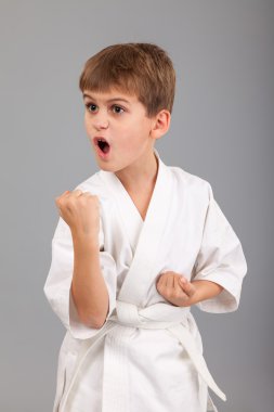 Beyaz kimonolu karateci çocuk dövüşüyor.