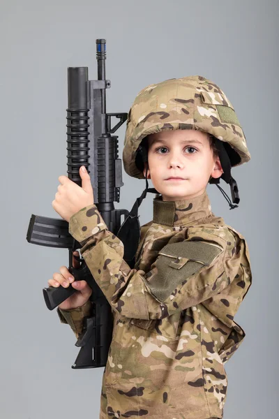 Young boy dressed like a soldier with rifle — Stock Photo, Image