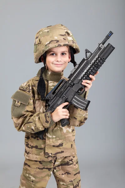 Young boy dressed like a soldier with rifle — Stock Photo, Image