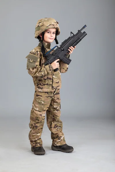 Young boy dressed like a soldier with rifle — Stock Photo, Image