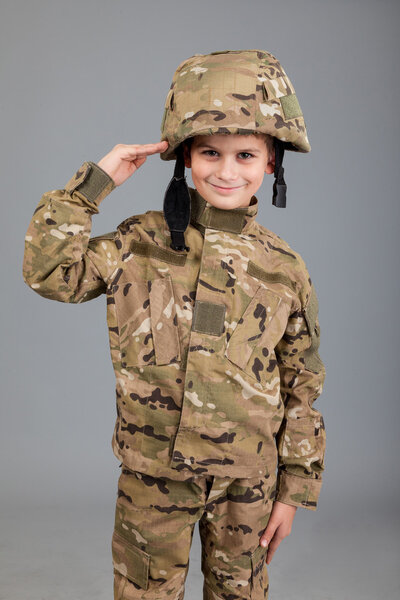 Saluting soldier. Young boy dressed like a soldier