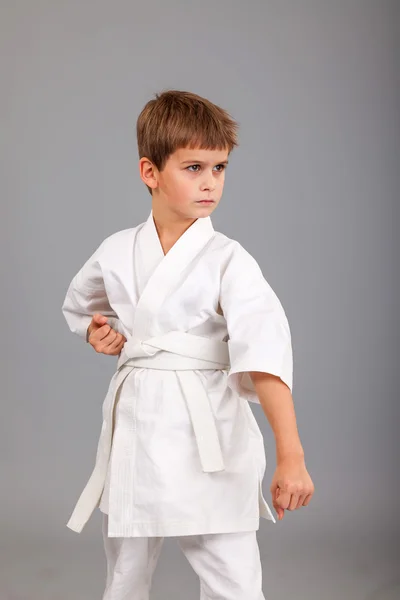 Karate-Junge im weißen Kimono kämpft — Stockfoto